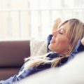 Relaxed young woman lying on couch