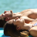 Relaxed,Couple,Sunbathing,On,Summer,Holiday,On,The,Beach,In