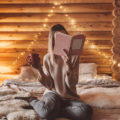 Woman,Relaxing,And,Reading,Book,On,Cozy,Bed,In,Log