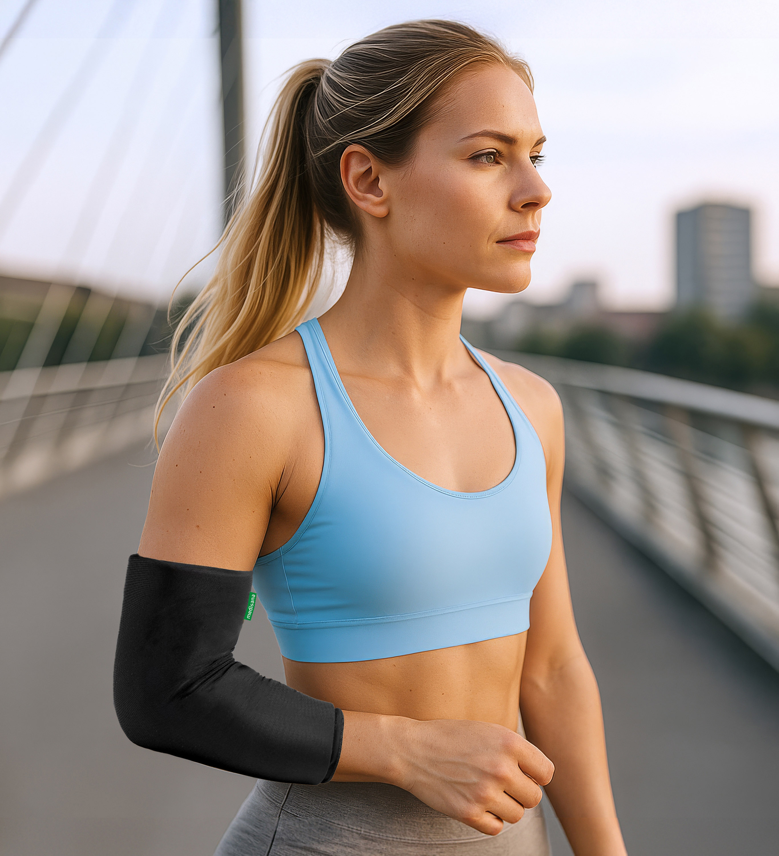 A woman running outdoors wearing a medisana arm gel pack