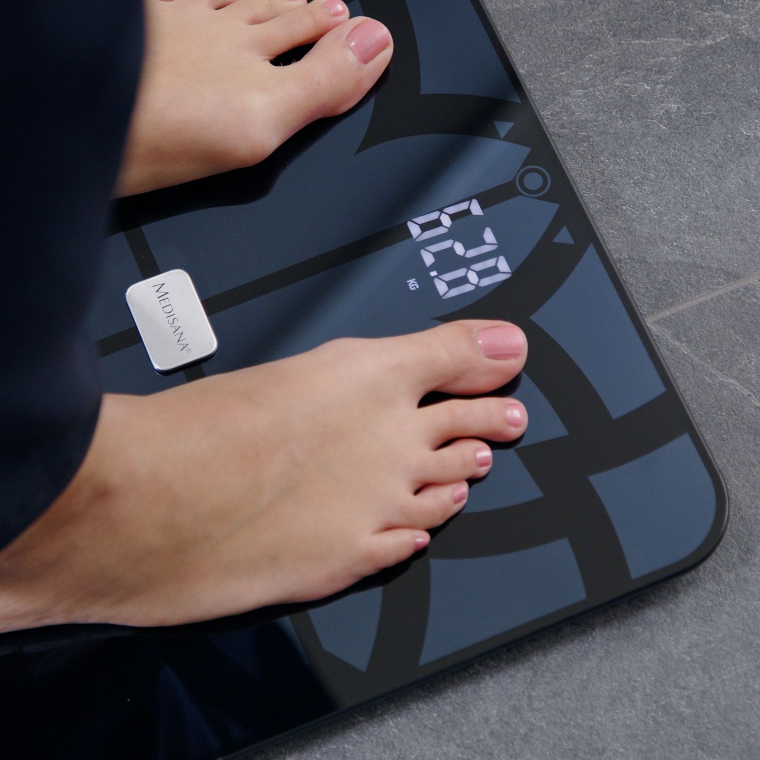 Close-up of feet on a digital bathroom scale displaying a weight of 62.8 kg.