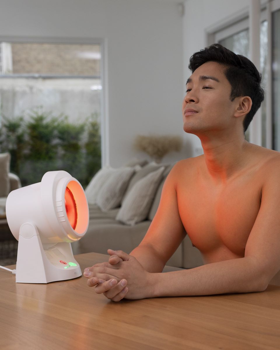 Person using the medisana infrared lamp for a soothing heat application in everyday life