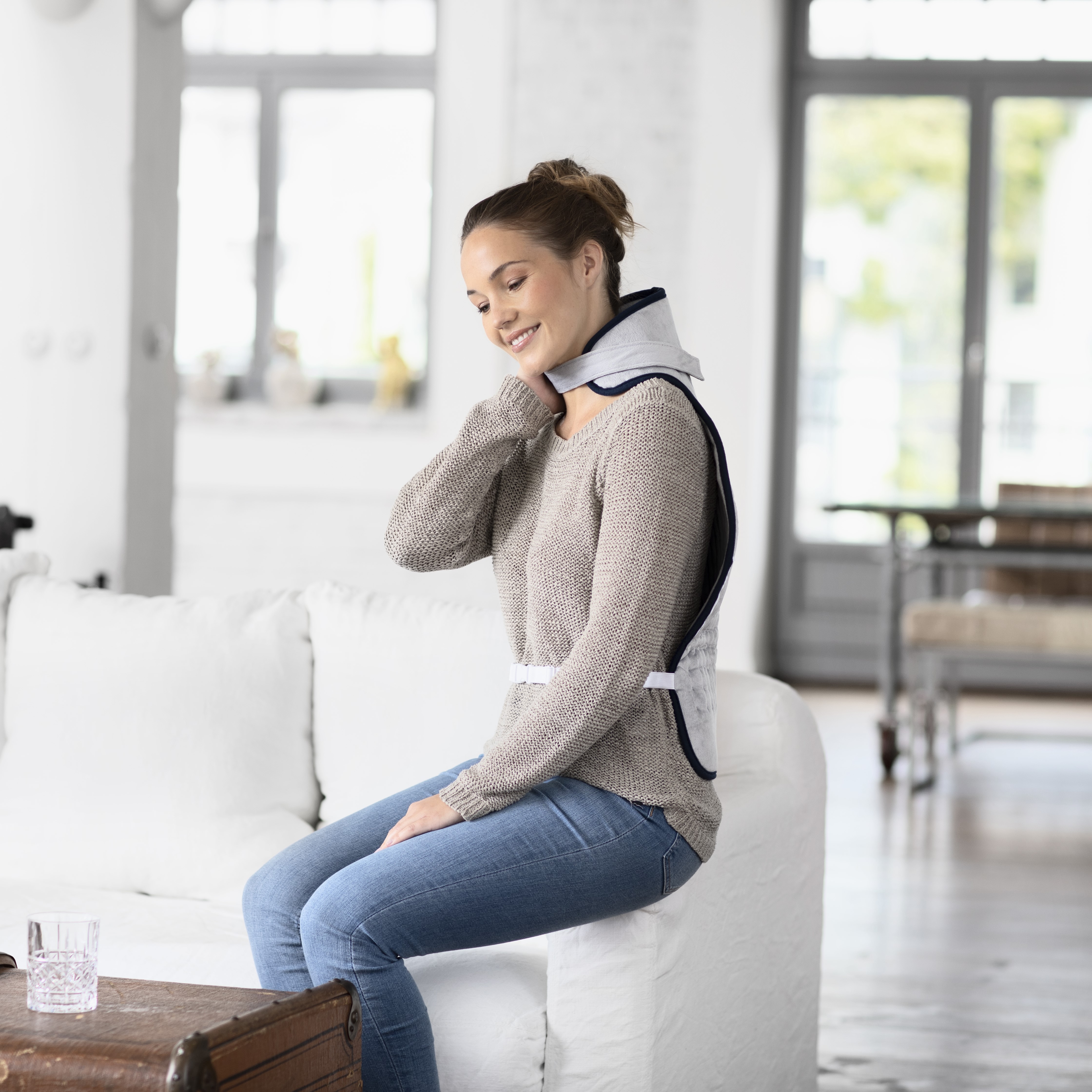 The user applies targeted heat to the neck area using the neck warmer to effectively loosen muscle tension.